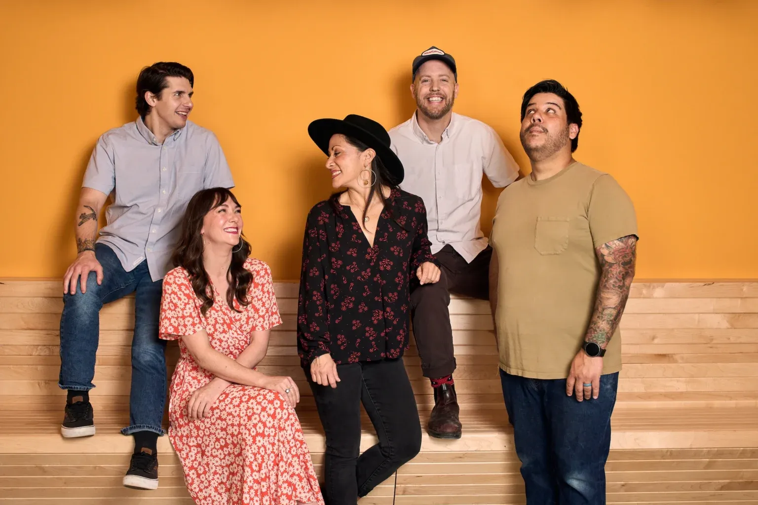 The Mala Pata team seated together against a saffron wall