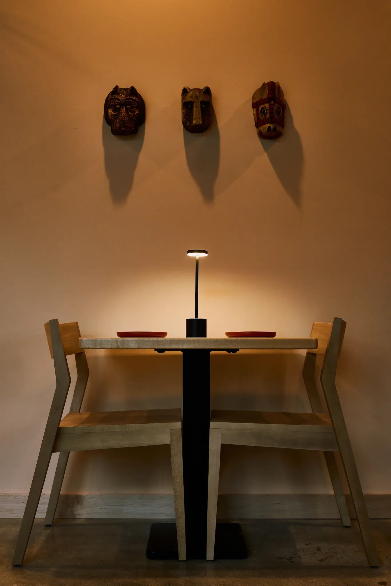 A table for two beneath carved masks