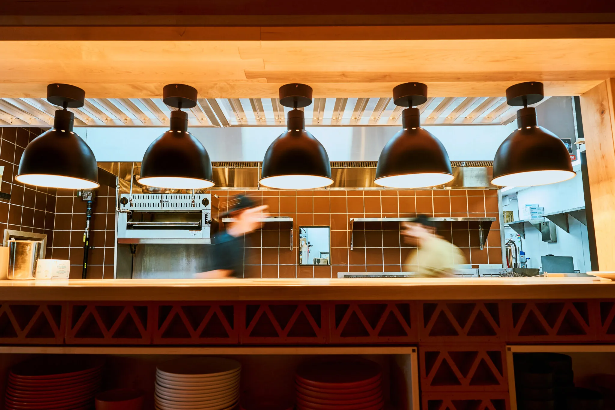 Cooks working the line under the heat lamps at Mala Pata